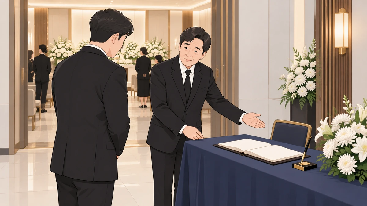 장례식장 빈소 입구에서 검은 정장을 입은 남성이 조문객에게 방명록 자리를 안내하는 모습