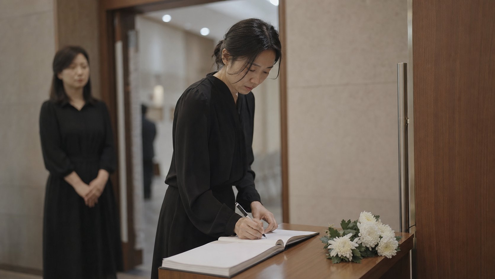장례식장 입구에서 조문객이 부의록에 이름을 작성하는 모습
