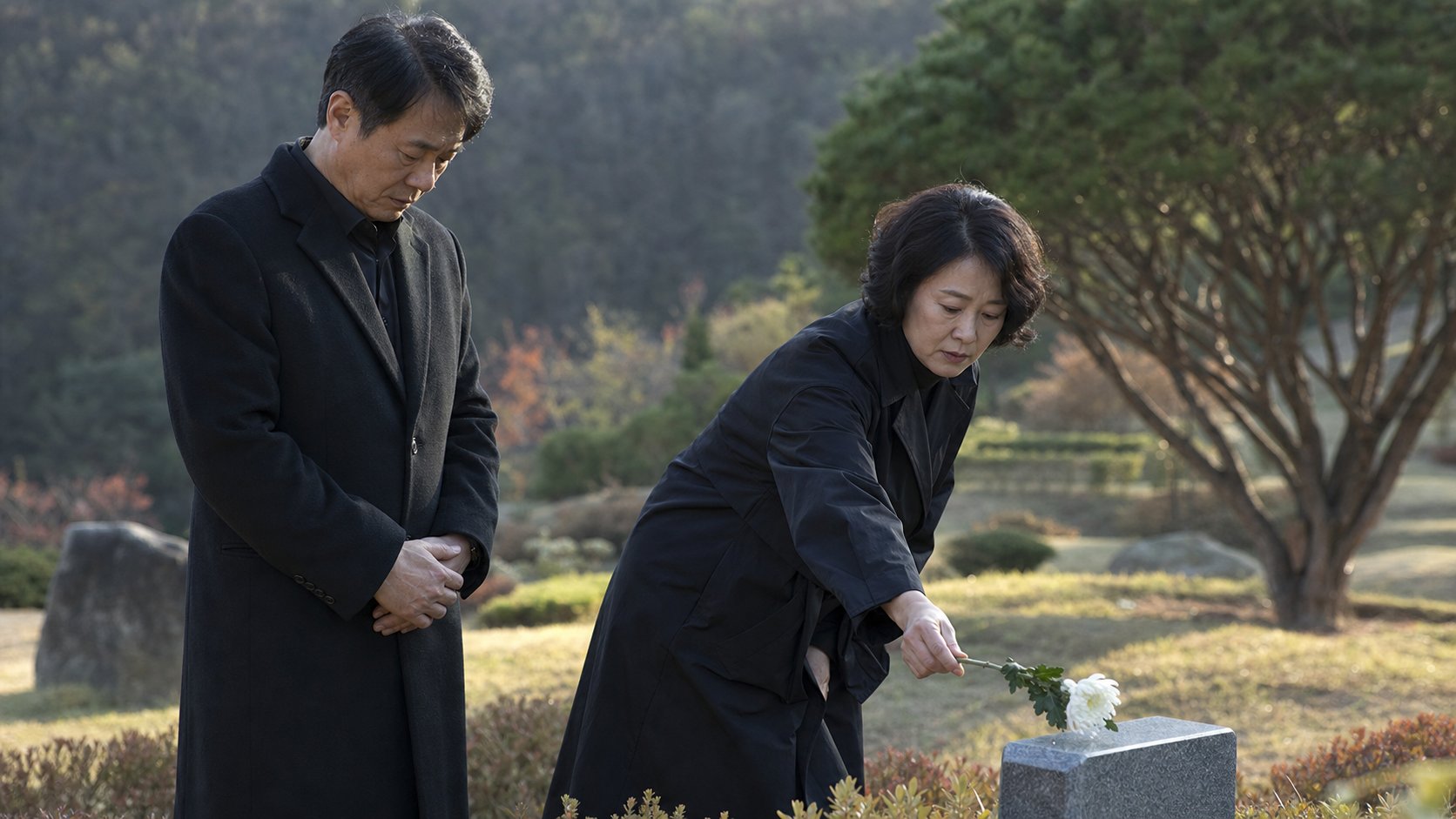 가족이 자연장지 표지석 앞에서 헌화하고 묵념하는 모습