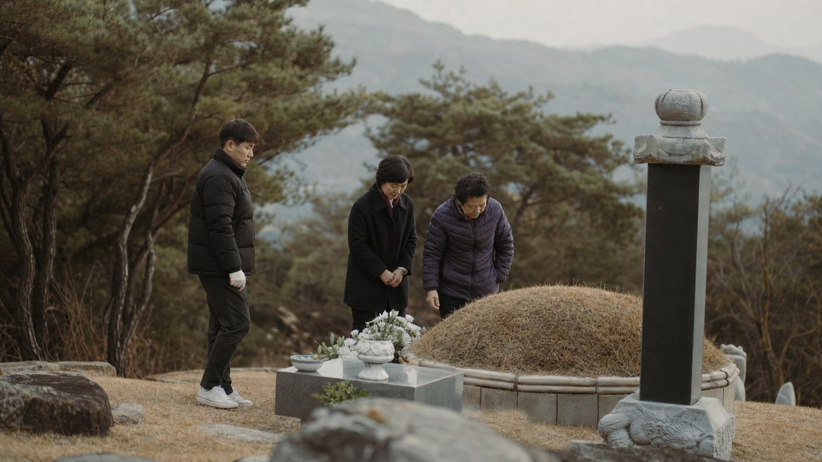 잘 단장된 봉분 앞에서 묘를 살피는 가족