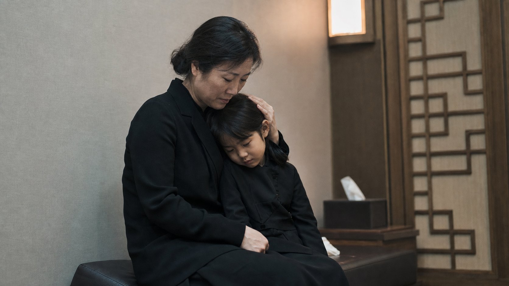 장례식장 가족실에서 어머니가 자녀를 안고 토닥이는 장면
