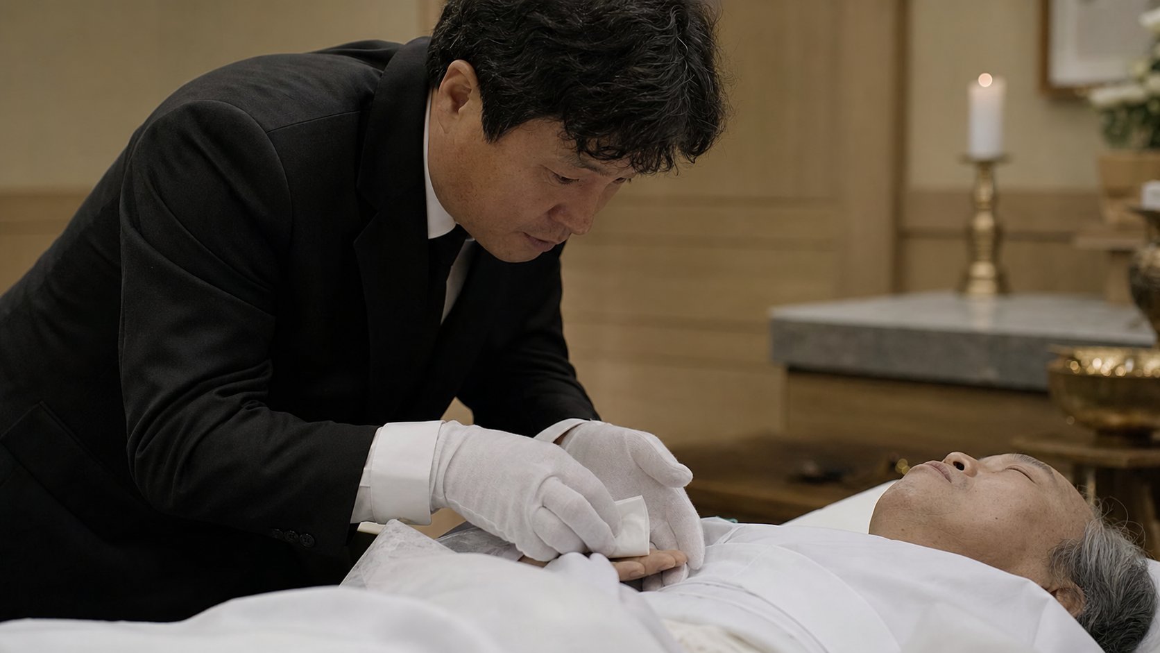 입관실에서 상주가 고인의 손에 노잣돈을 쥐어드리는 모습