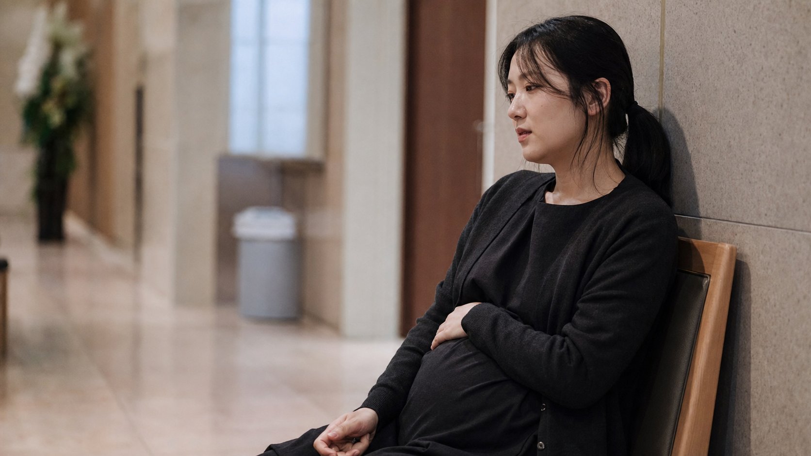 임산부가 장례식장 로비 의자에서 잠시 휴식하는 모습