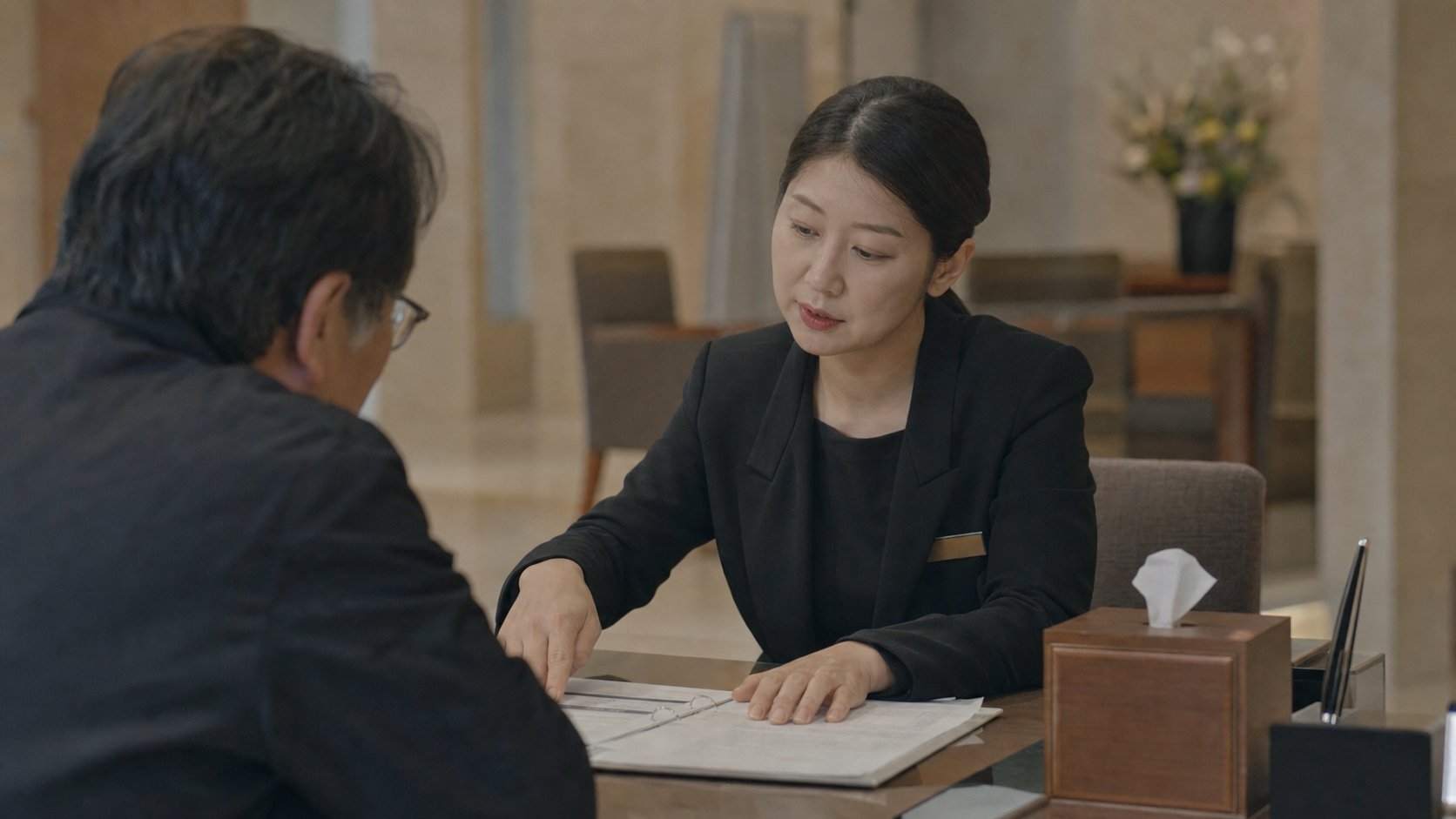 안내 데스크에서 예약과 요금을 설명하는 직원