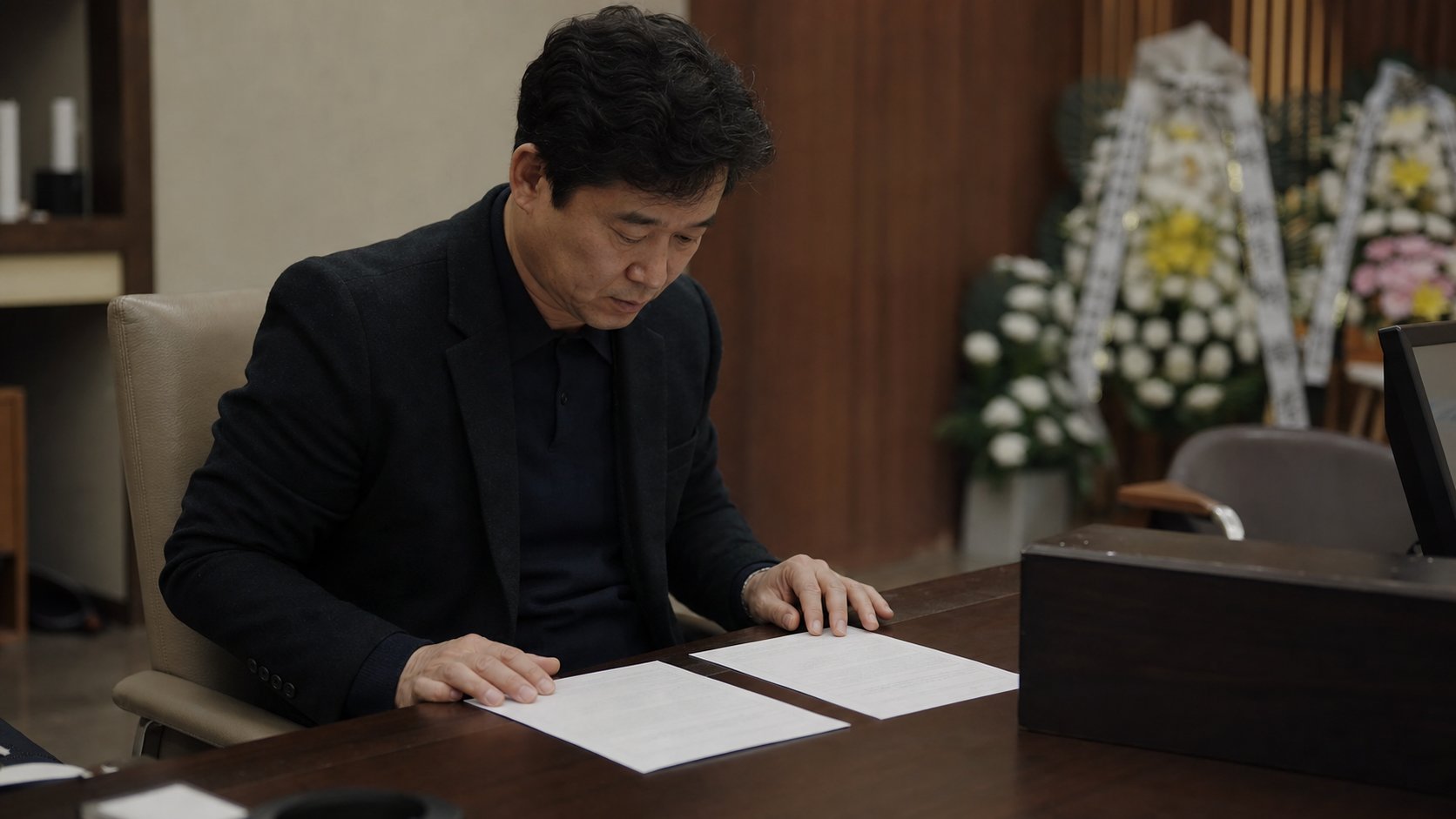 유가족이 정산 영수증과 계약서를 나란히 놓고 비용 항목을 비교하며 확인하는 모습