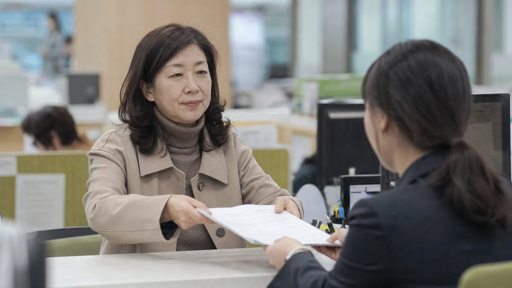 주민센터 창구에서 서류를 제출하는 장면