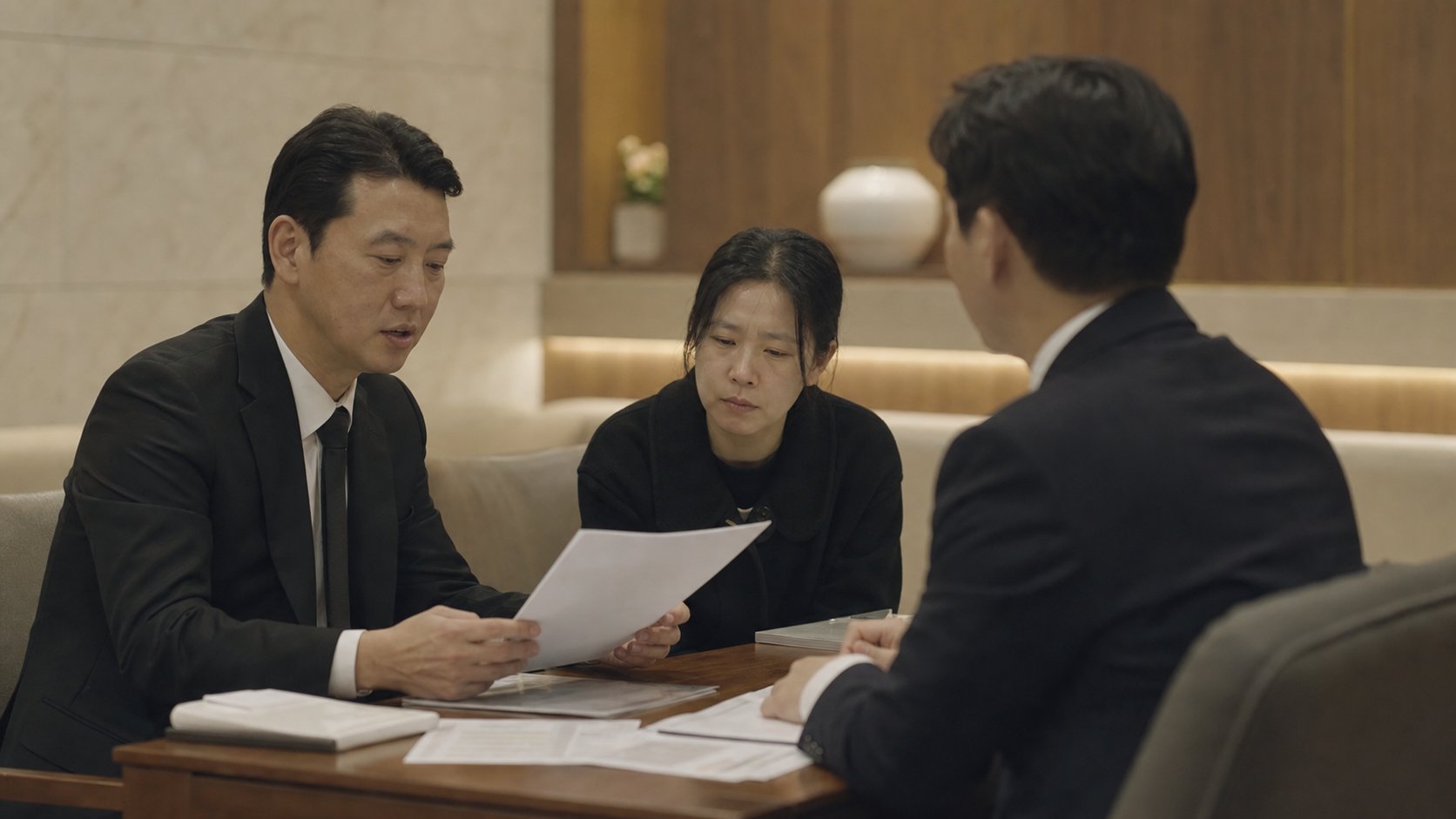 유족이 사망진단서와 서류를 들고 장례지도사와 장례 방향을 상의하는 모습