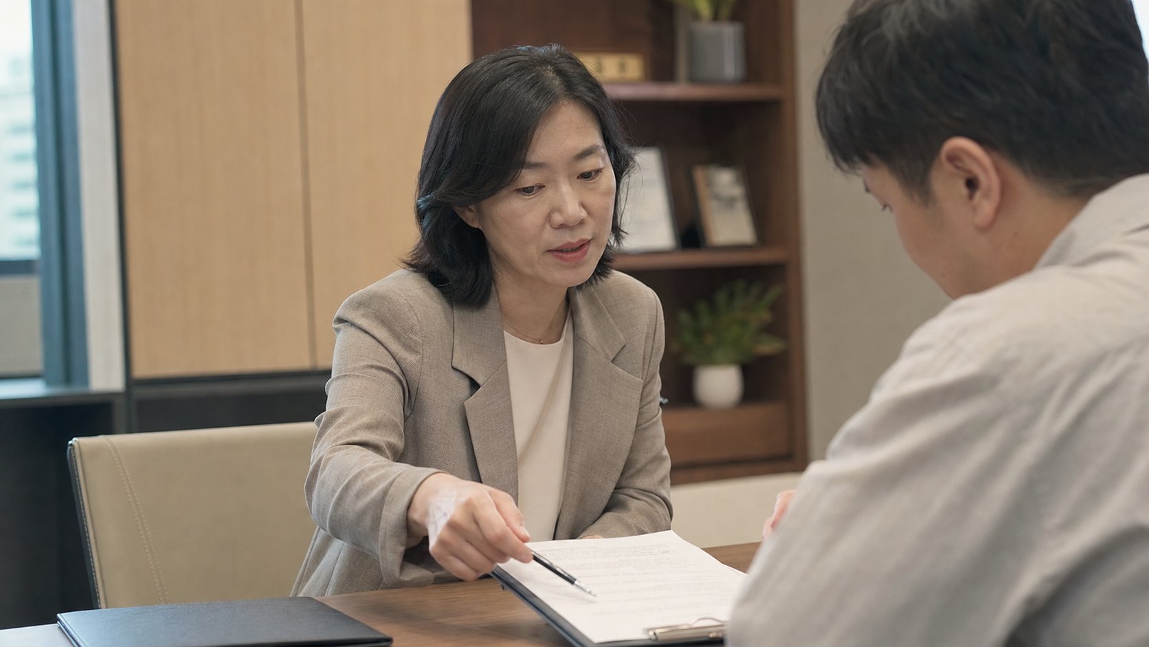 상담 창구에서 새 계약 조건을 안내받는 장면