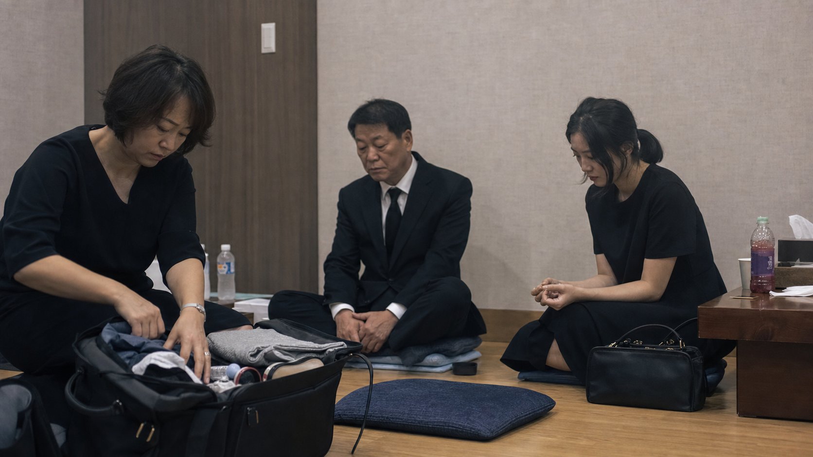 장례식장 가족대기실에서 짐을 정리하며 쉬는 가족