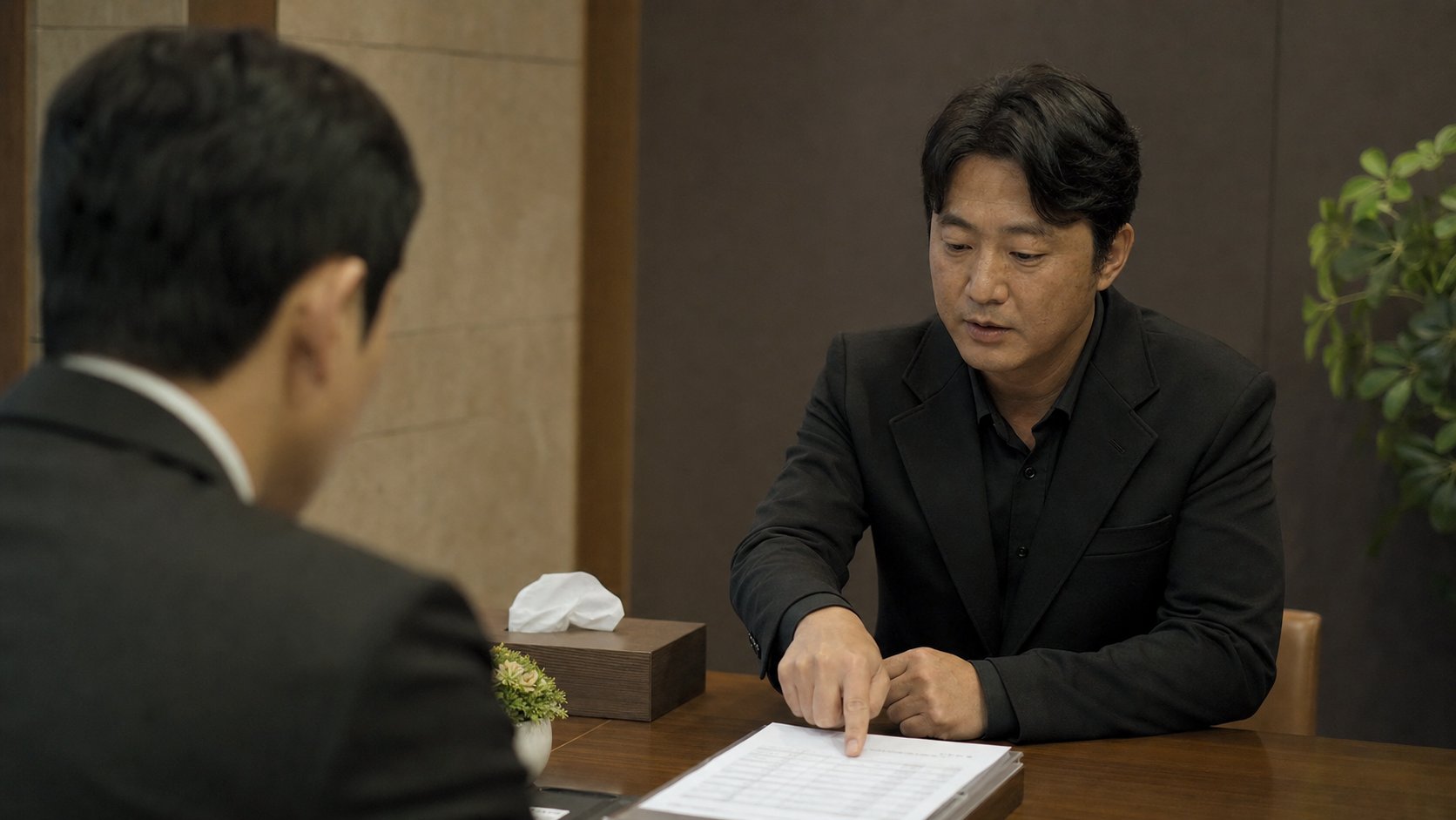 견적서를 짚으며 담당자에게 의사를 전달하는 상주