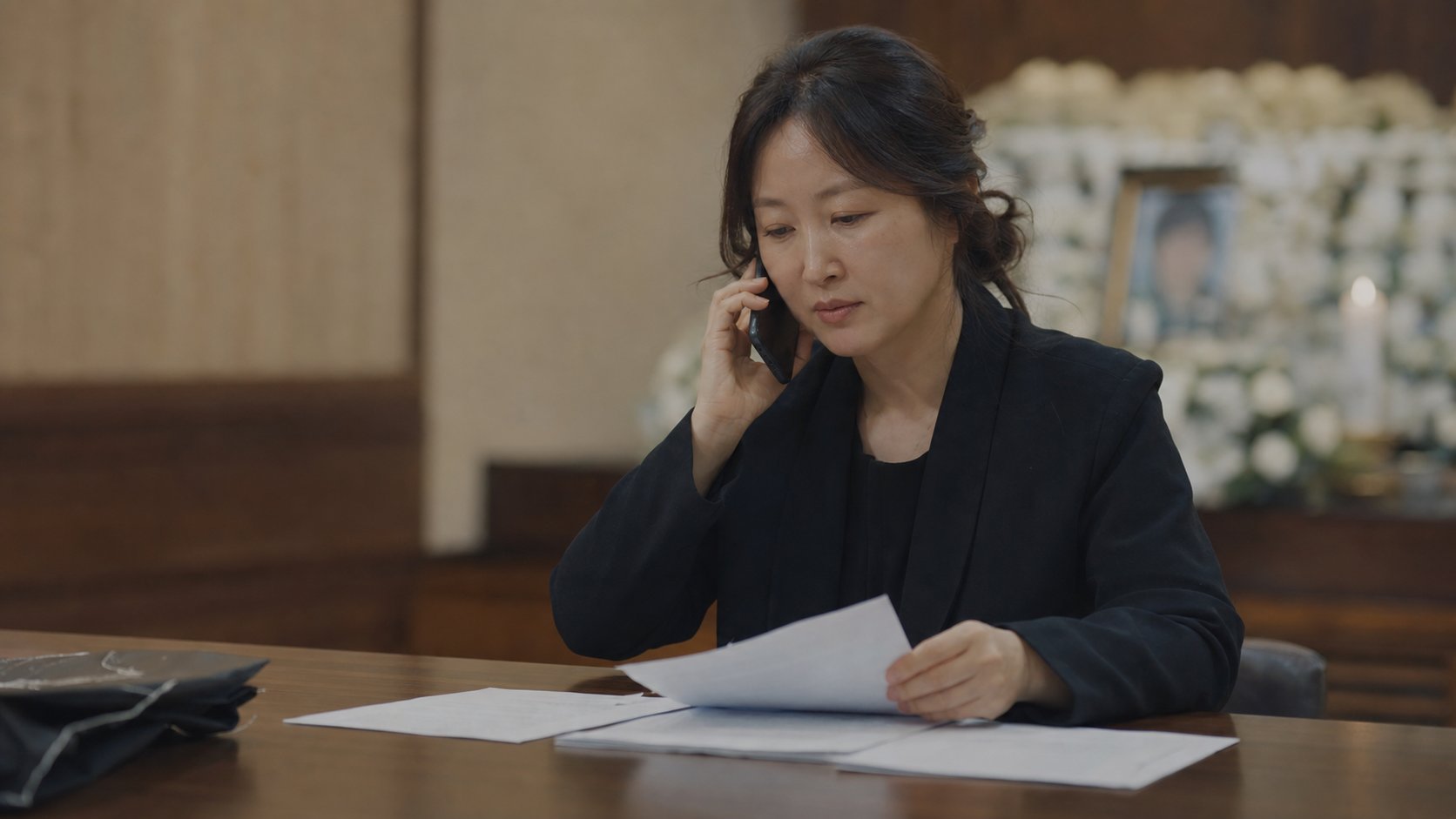 소비자 상담 창구에 전화로 문의하며 서류를 살펴보는 유족