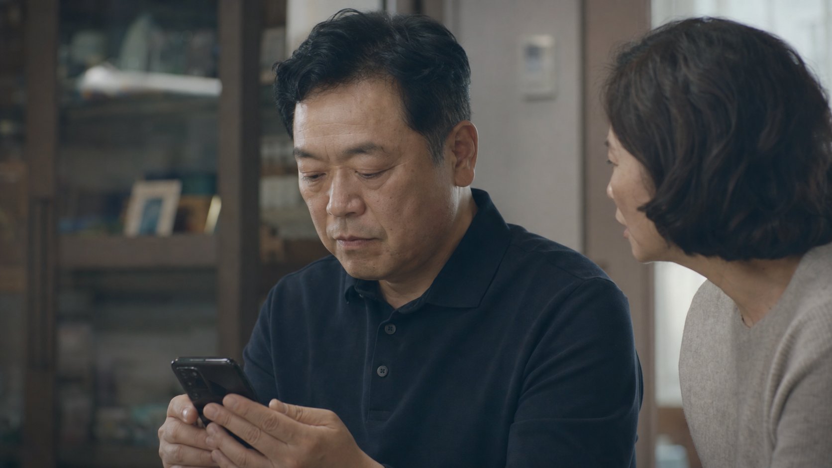 유가족이 조용한 공간에서 부고를 가까운 친척에게 문자로 전하며 상의하는 모습