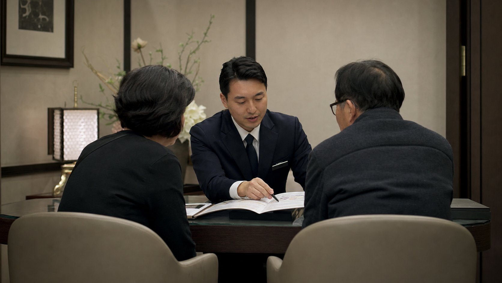 장례식장 상담실에서 장례지도사가 유가족에게 비용 항목을 설명하는 모습