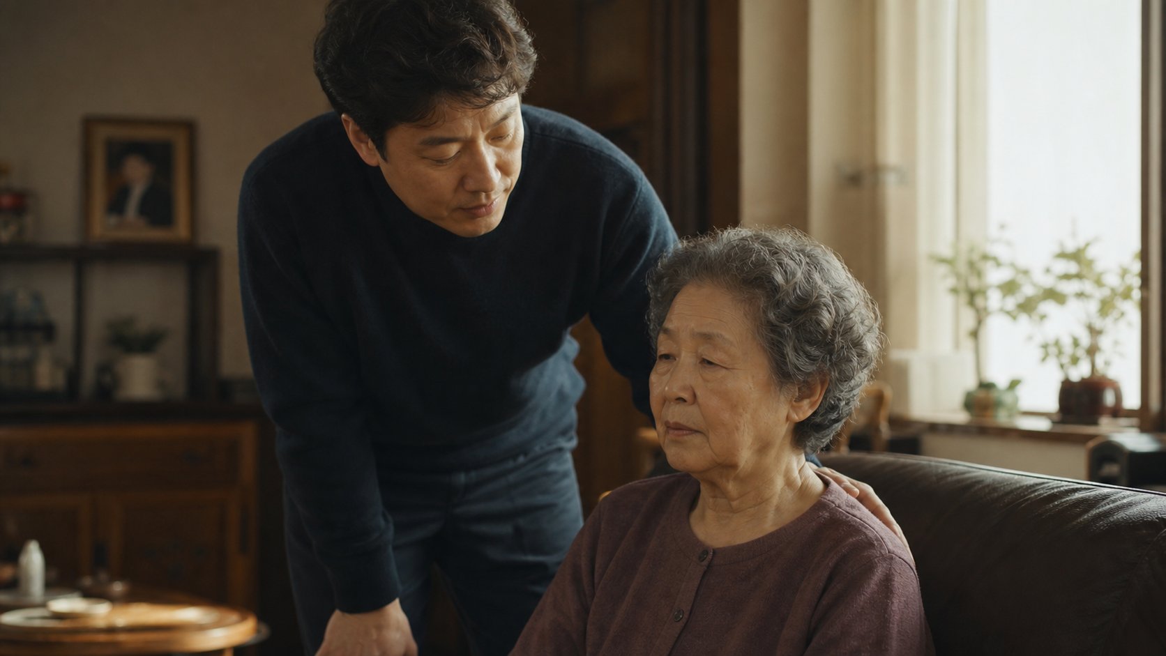 성인 자녀가 형제를 잃은 어머니의 어깨에 손을 얹고 위로하는 모습