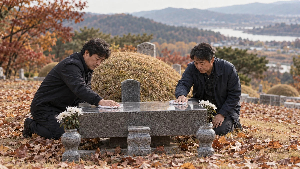 가을 공원묘지에서 형제가 상석을 닦으며 성묘하는 모습