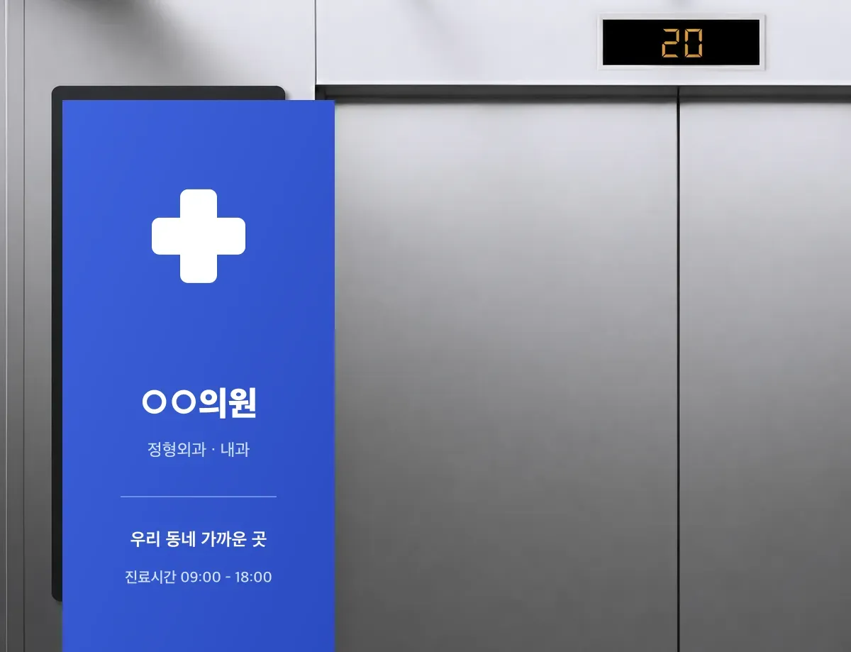 아파트 엘리베이터 앞 세로형 디지털 스크린에 동네 병원 광고가 송출되는 실제 모습
